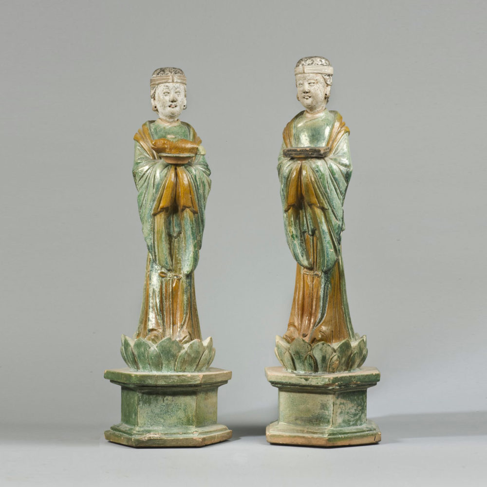 A pair of glazed terracotta standing female attendants